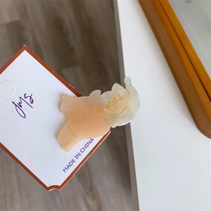 Detail of cute cat-shaped hair clips in orange and marble white acetate material