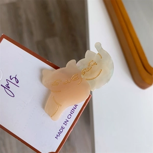 Detail of pink and white cat-shaped hair clips made of smooth acrylic material