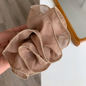 Detailed close-up of light coffee organza hair scrunchie with ruffled edge texture