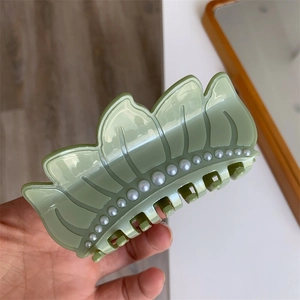 Elegant green lotus seedpod hair claw clip with pearls and artistic leaf design