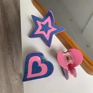 Détail de pinces à cheveux en forme d'étoile et cœur avec texture denim rose et bleu