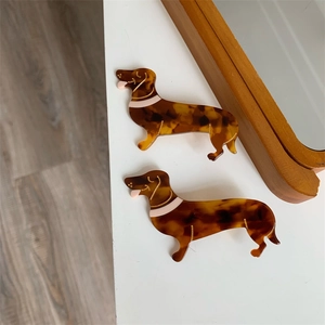 Nahaufnahme der Acetat-Haarklammern in Dackelform mit eleganten goldenen Linien-Details