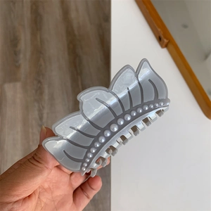 Detail of grey crown hair claw clip with faux pearl embellishments and multi-tooth grip