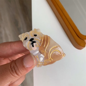 Nahaufnahme einer niedlichen Bulldogge-Haarklammer aus Acetat mit feinen Golddetails