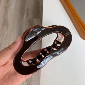 Close-up of a large tortoiseshell acetate hair claw with golden Amy Bear handmade logo