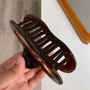 Detail of a large amber tortoiseshell hair claw clip for thick hair styling