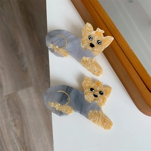 Makroaufnahme von zwei Acetat-Haarspangen im Yorkshire-Terrier-Design mit Marmortextur