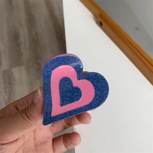 Détail d'une pince à cheveux en forme de cœur avec couches rose et bleu denim