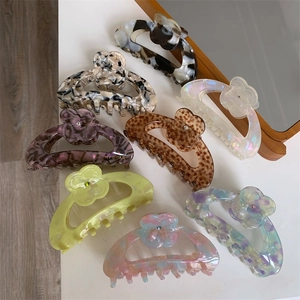 Various floral acetate hair claws with marble and tortoiseshell patterns in a collection