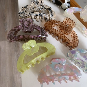 Detailed view of floral acetate hair claws with marble and tortoiseshell patterns