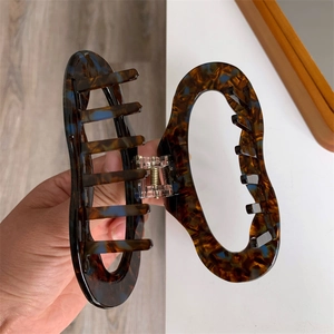 Close-up of geometric acetate hair claw clip with dark blue tortoiseshell pattern
