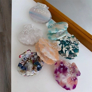 Détail de diverses pinces à cheveux en acétate coloré en forme de coquillage