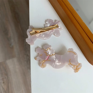 Detail von zwei lavendelfarbenen Pudel-Haarspangen aus Acetat mit goldenem Entenschnabelclip