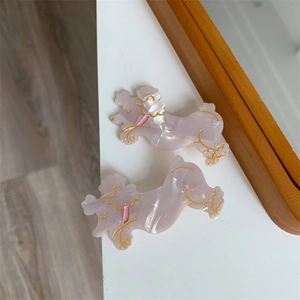 Detail der beiden rosa Pudel-Haarklammern mit eleganten goldenen Umrissen