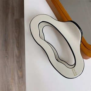 Detail view of large acetate hair claw clip with black borders and wave shape design