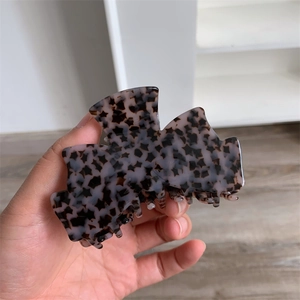 Détail d'une grande pince à cheveux en acétate avec motifs étoilés et finition violette