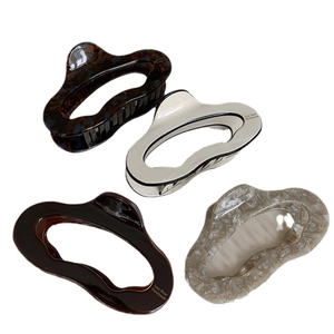 French style irregular acetate hair claws in dark tortoise, cream, and marble patterns
