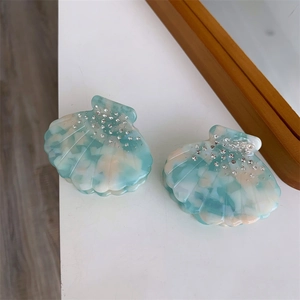 Détail macro d'une pince à cheveux en acétate en forme de coquille avec strass