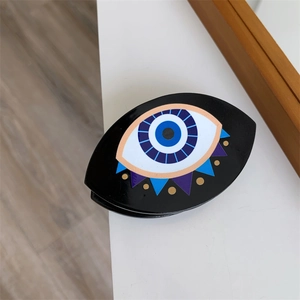Dettaglio del fermaglio nero per capelli Evil Eye con accenti colorati per Halloween