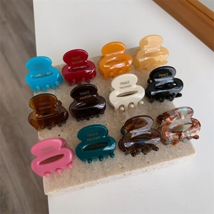 Gros plan de mini pinces à cheveux en acétate avec inscription dorée France Handmade