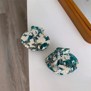 Détail des pinces à cheveux en acétate en forme de coquille avec texture marbrée