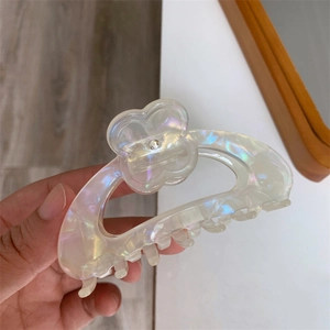 Detailed macro view of pearlescent flower hair claw clip with floral clover decoration