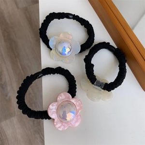 Detailed shot of three floral hair ties in pastel pink and white with elastic fabric