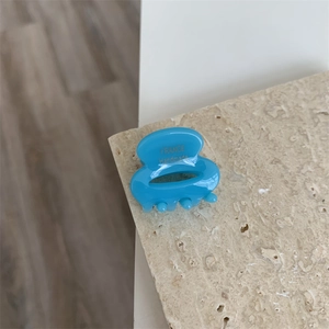 Détail du petit clip cheveux en acétate bleu avec logo doré France Handmade imprimé