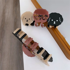 Détail de pinces à cheveux chien mignon en acétate beige, marron et noir brillant