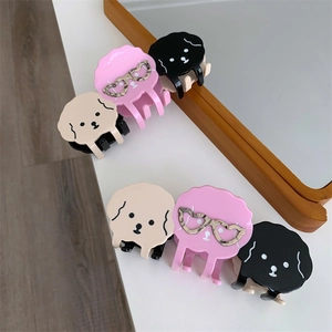 Détail de pinces à cheveux poodles mignons en rose et beige sur une table de toilette