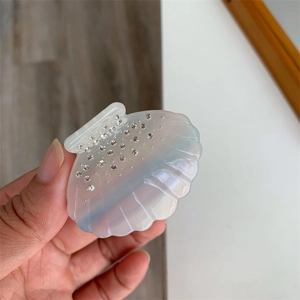 Vue détaillée d'une pince à cheveux en forme de coquillage avec strass et effet nacre