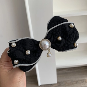 Elegant black quilted bow hair clip with faux pearl and rhinestone embellishments