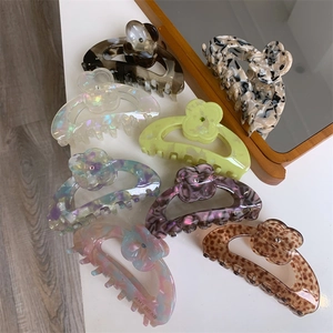 Macro detail of acetate flower hair claw clips in various elegant marbled patterns