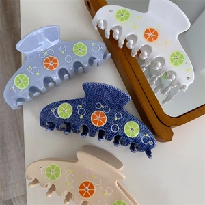 Macro view of citrus print hair claws with sparkling rhinestones and acetate finish