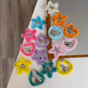 Dettaglio di fermagli per capelli in peluche a forma di cuore e stella con strass colorati