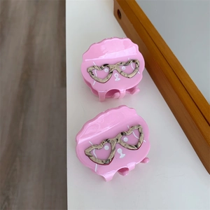 Détail des pinces à cheveux chien rose avec lunettes de soleil coeur motif marbre