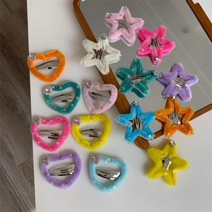 Dettaglio di fermagli per capelli in peluche a forma di cuore e stella con strass lucidi