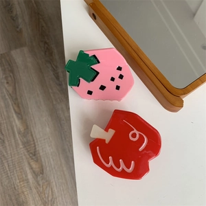 Close-up of cute strawberry and apple fruit shaped hair claws with glossy finish
