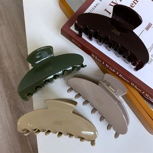 Detail of four acetate claw clips in earth tones with Barrette La France gold lettering