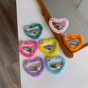 Dettaglio di fermagli per capelli a cuore in peluche colorato con strass e stelle