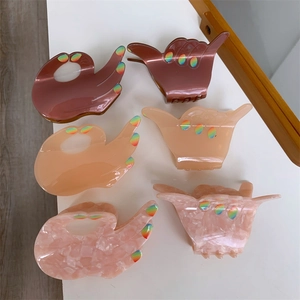 Detailed view of acetic acid shark hair clips in various gesture shapes with glitter accents