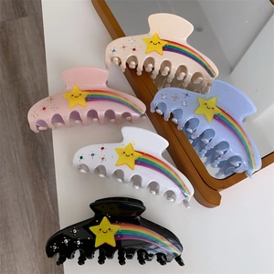 Close-up of acetic acid hair clips set with star, rainbow patterns and shiny rhinestones