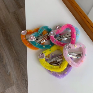 Dettaglio di fermagli per capelli a cuore pelosi con paillettes a stella e strass