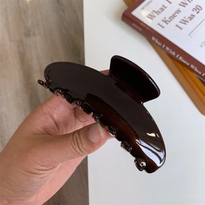 Retro chocolate brown large hair claw clip with glossy finish and minimalist curved design