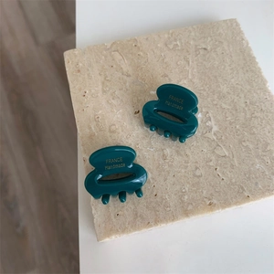 Gros plan de petites pinces à cheveux vert foncé avec lettrage doré France Handmade