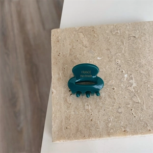 Détail de la pince à cheveux en acétate vert foncé avec lettrage doré France Handmade