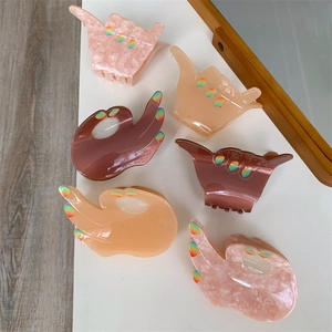 Detail showing creative hand gesture acetate hair claws in various stylish colors