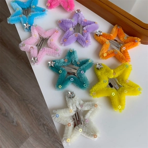Dettaglio di fermagli per capelli a stella in peluche colorato con paillettes e stelle