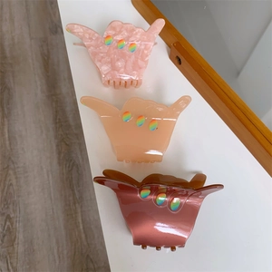 Three-piece acetate shaka sign gesture claw clips in marble pink and gloss brown
