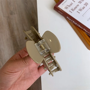 Detail showing high-elasticity metal spring of a khaki acetate hair claw clip